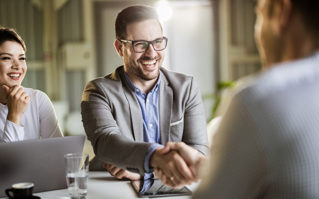 Business professionals negotiating a merger deal with Meritus Group's advisory