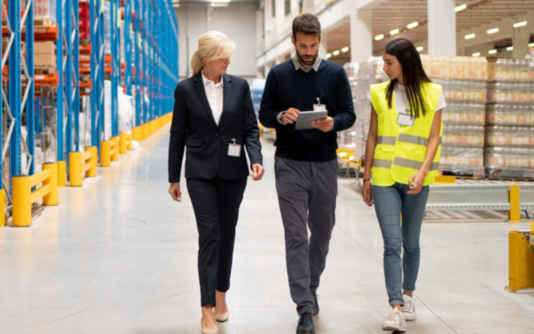 A businessman shaking hands with a buyer in a manufacturing facility